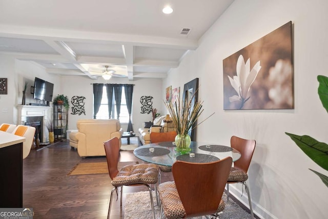 dining room featuring dark hardwood / wood-style flooring, coffered ceiling, ceiling fan, and beam ceiling