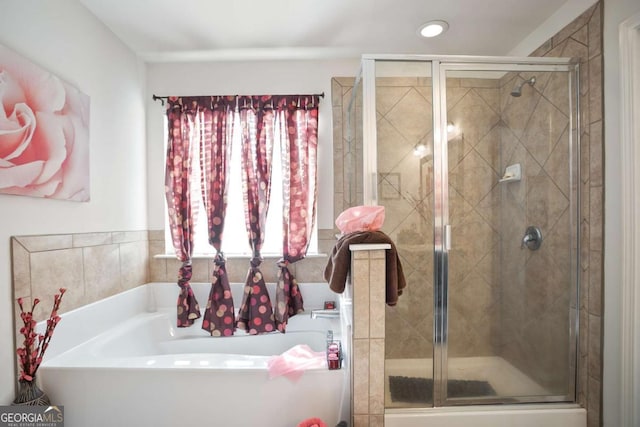 bathroom featuring a wealth of natural light and plus walk in shower