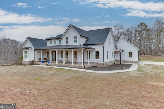 modern inspired farmhouse featuring a porch and a front yard