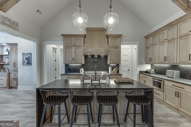 4621 Stanley Rd, Flowery Branch, GA 30542 - kitchen with high vaulted ceiling, dark countertops, custom range hood, tasteful backsplash, and a sink