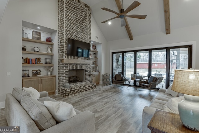 4621 Stanley Rd, Flowery Branch, GA 30542 - living room featuring high vaulted ceiling, a ceiling fan, wood finished floors, a fireplace, and built in features