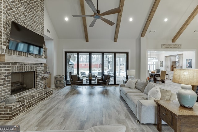 4621 Stanley Rd, Flowery Branch, GA 30542 - living room featuring high vaulted ceiling, ceiling fan, wood finished floors, a brick fireplace, and beamed ceiling