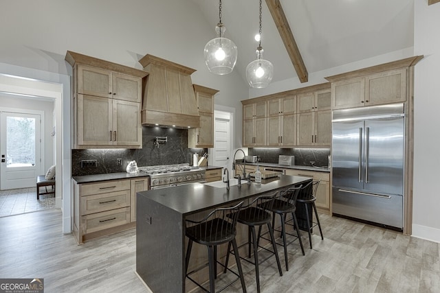 4621 Stanley Rd, Flowery Branch, GA 30542 - kitchen featuring premium appliances, dark countertops, high vaulted ceiling, light wood finished floors, and backsplash