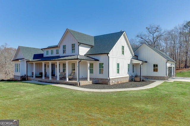 exterior space featuring metal roof, covered porch, a yard, roof with shingles, and board and batten siding