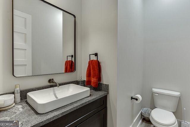 4621 Stanley Rd, Flowery Branch, GA 30542 - bathroom with toilet, vanity, and baseboards