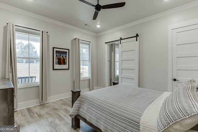 4621 Stanley Rd, Flowery Branch, GA 30542 - bedroom with light wood-type flooring, crown molding, a barn door, multiple windows, and baseboards