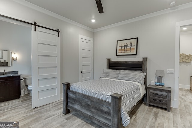 4621 Stanley Rd, Flowery Branch, GA 30542 - bedroom featuring a sink, a barn door, crown molding, light wood finished floors, and ensuite bath