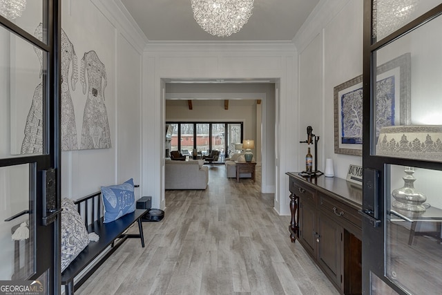 4621 Stanley Rd, Flowery Branch, GA 30542 - corridor with ornamental molding, a chandelier, a decorative wall, and light wood-type flooring