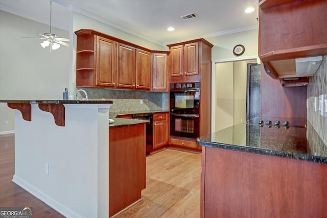 kitchen with black appliances, dark stone counters, tasteful backsplash, kitchen peninsula, and crown molding