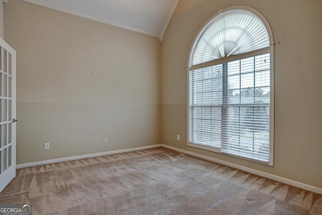 unfurnished room featuring light colored carpet, vaulted ceiling, and ornamental molding