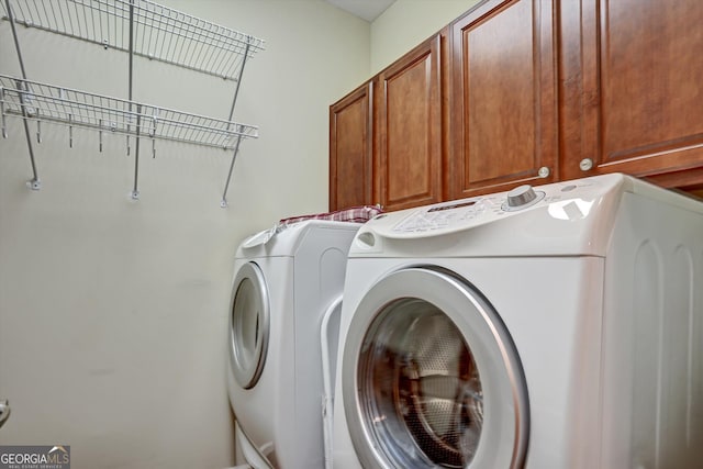 washroom with cabinets and washing machine and dryer