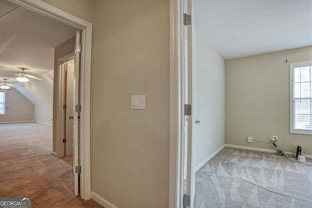 hall featuring light carpet and vaulted ceiling