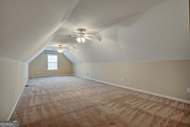 additional living space featuring light carpet and vaulted ceiling