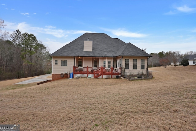 back of property with a lawn and a deck