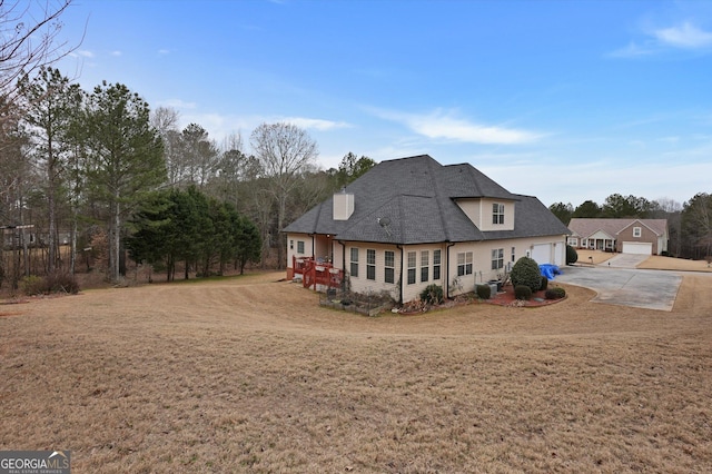 rear view of property with a garage and a yard