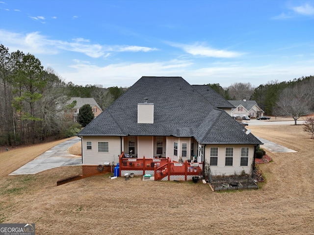 rear view of house with a yard and a wooden deck