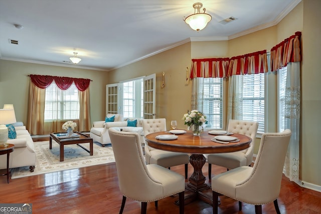 dining area featuring crown molding and hardwood / wood-style flooring