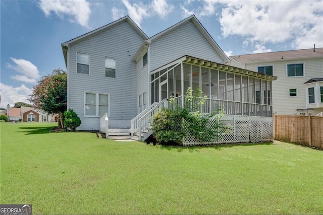 back of property with a sunroom and a lawn