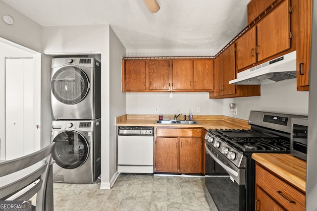 kitchen featuring sink, ceiling fan, dishwasher, stainless steel gas stove, and stacked washing maching and dryer