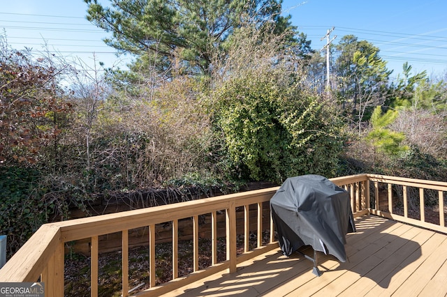 wooden deck featuring a grill