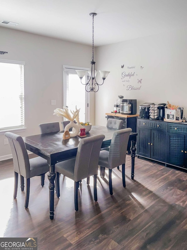 dining space featuring an inviting chandelier and dark hardwood / wood-style floors