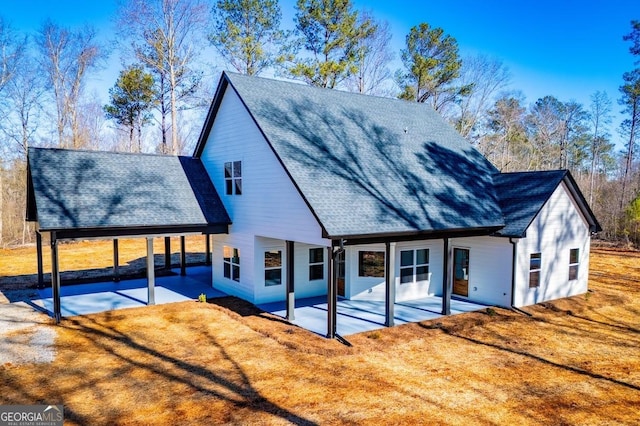 back of house featuring a patio area, a yard, and roof with shingles