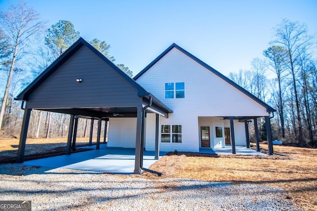 exterior space with a ceiling fan, an attached carport, a patio, and driveway