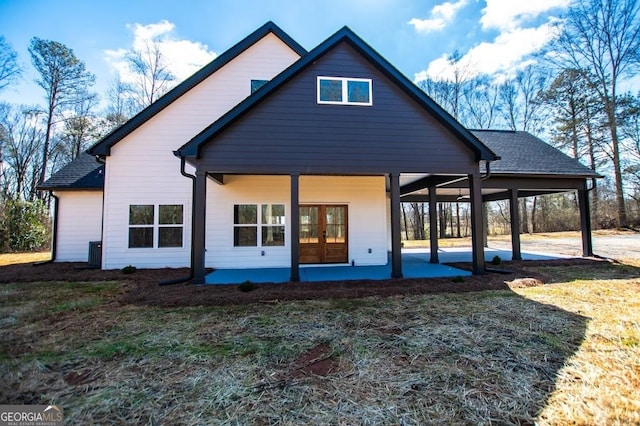 rear view of house featuring a shingled roof and a patio