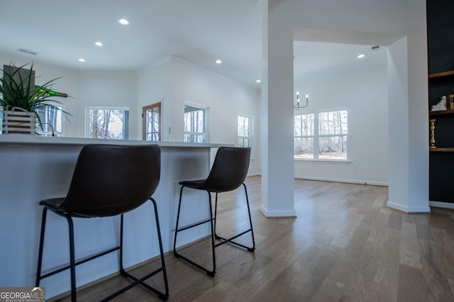 kitchen featuring an inviting chandelier, hardwood / wood-style floors, and a breakfast bar