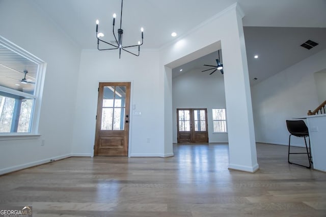 entrance foyer with high vaulted ceiling, ornamental molding, baseboards, and wood finished floors