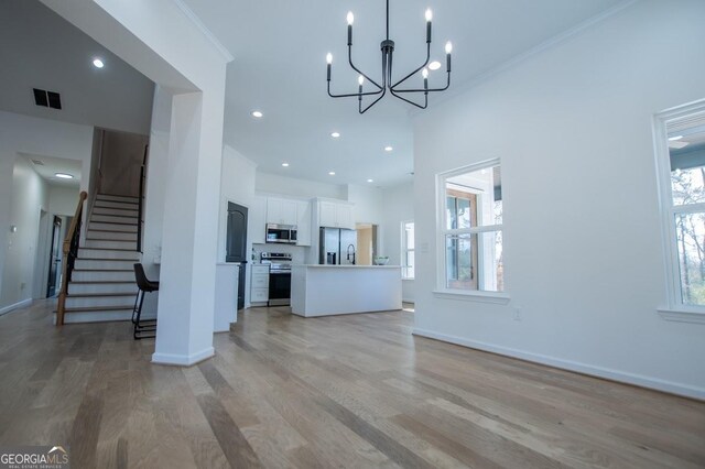 kitchen featuring light wood-type flooring, appliances with stainless steel finishes, and white cabinetry