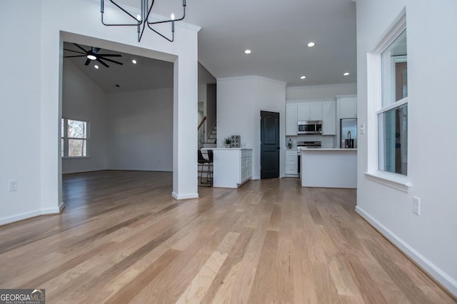 unfurnished living room featuring crown molding, recessed lighting, light wood-style flooring, stairway, and baseboards