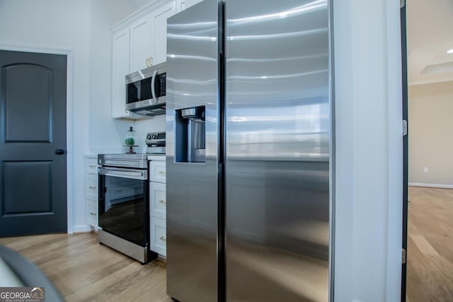 kitchen featuring light wood-type flooring, baseboards, white cabinetry, and stainless steel appliances