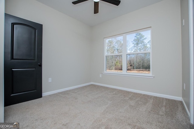 spare room with ceiling fan and light colored carpet