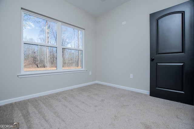 carpeted empty room with baseboards