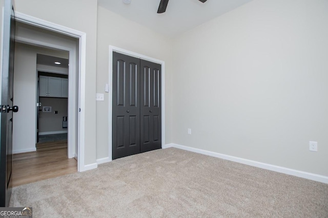 unfurnished bedroom featuring a closet, carpet, a ceiling fan, and baseboards