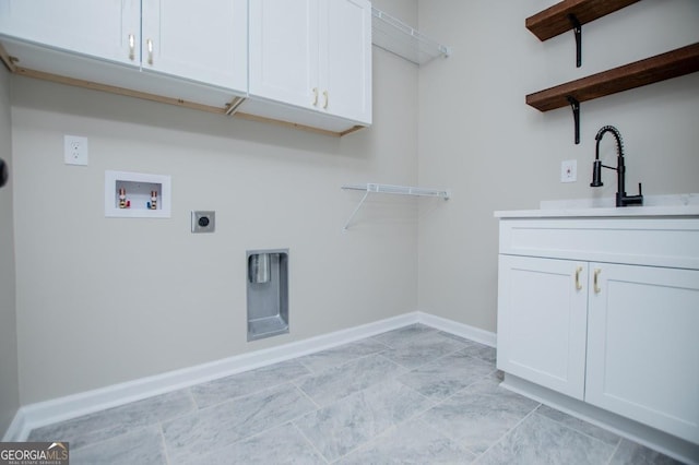 laundry area with washer hookup, cabinet space, a sink, electric dryer hookup, and baseboards