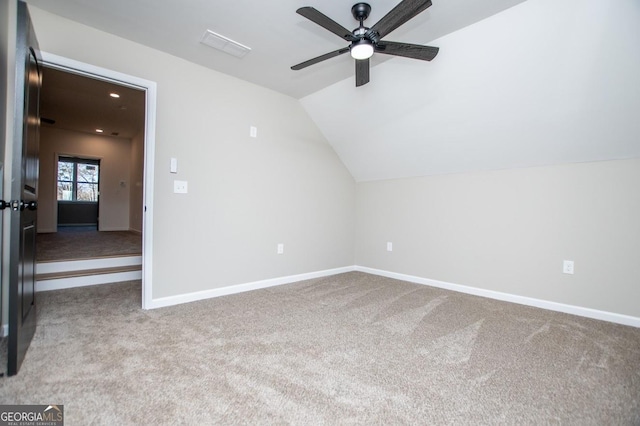 additional living space with light carpet, ceiling fan, and vaulted ceiling