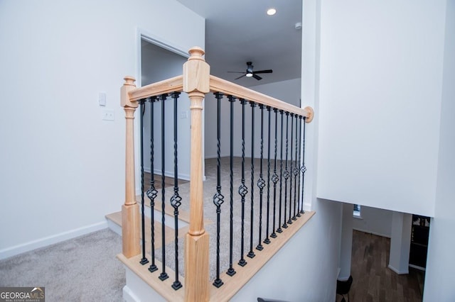 staircase with a ceiling fan, carpet, and baseboards