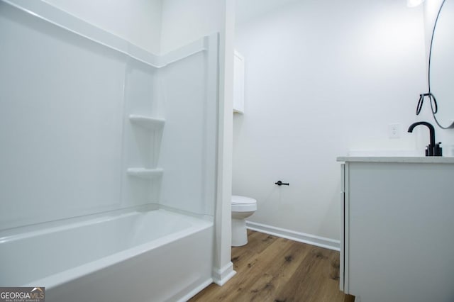 full bath with toilet, baseboards, wood finished floors, and vanity