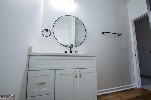 bathroom with vanity, baseboards, and wood finished floors