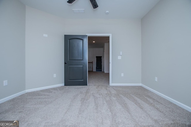 spare room featuring ceiling fan and light colored carpet