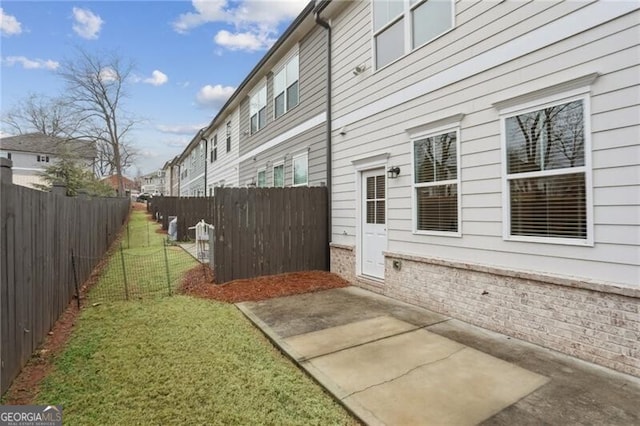 view of side of home featuring a yard and a patio