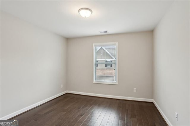 spare room with dark wood-type flooring