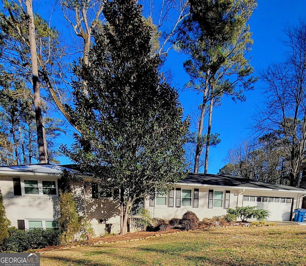 view of front of property featuring a garage and a front lawn