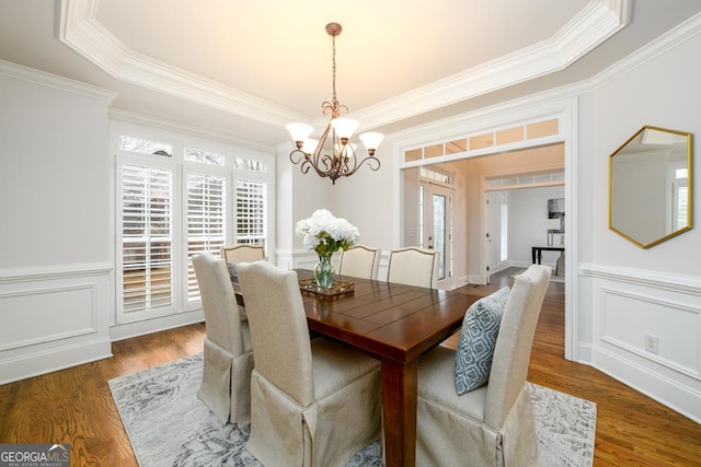 dining space with crown molding, a chandelier, and dark hardwood / wood-style flooring