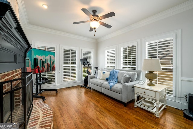 living room featuring hardwood / wood-style flooring, ceiling fan, and ornamental molding