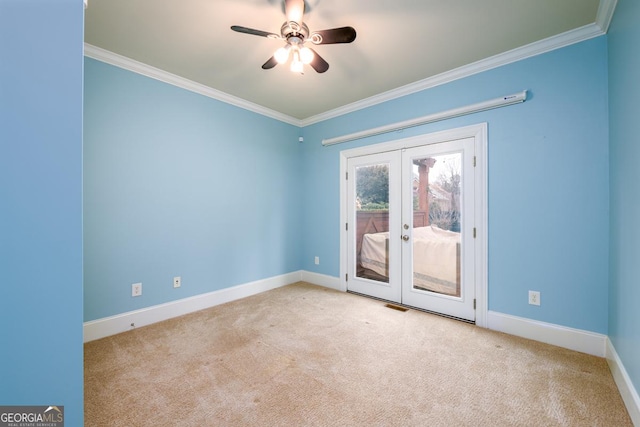 carpeted spare room featuring ceiling fan, french doors, and crown molding