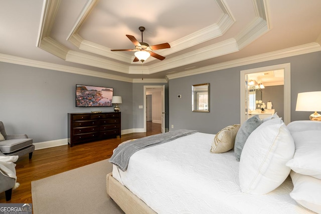 bedroom featuring a raised ceiling, ornamental molding, ceiling fan, connected bathroom, and dark hardwood / wood-style floors