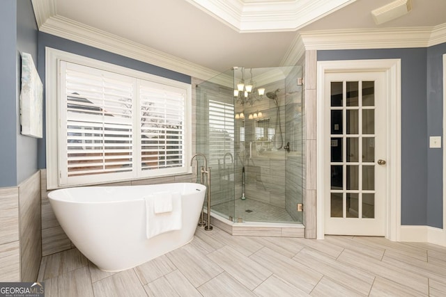 bathroom with tile walls, ornamental molding, and shower with separate bathtub